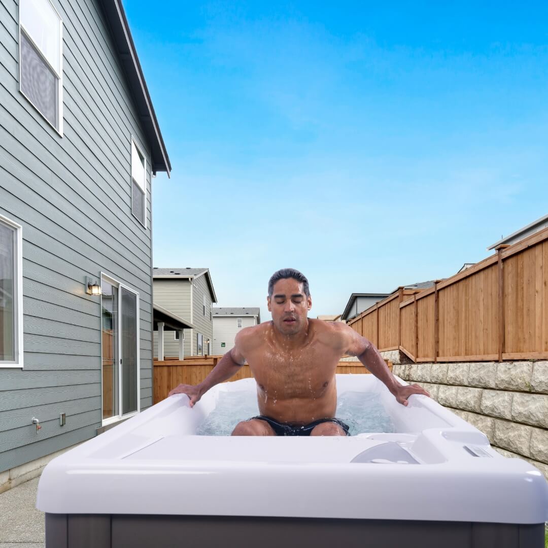 man practicing contrast therapy by dipping into a cold plunge tub